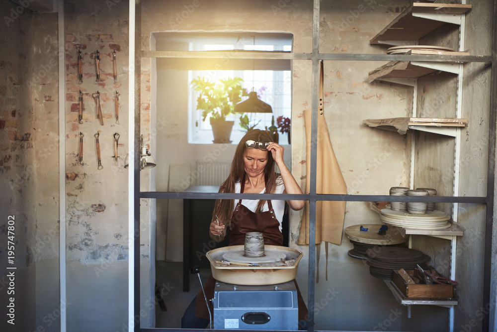 Artisan working at a pottery wheel in her creative studio