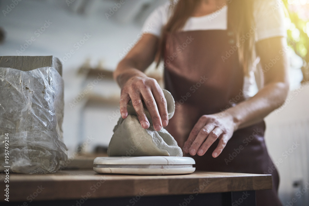 女工匠在她的陶瓷作坊里称量粘土块