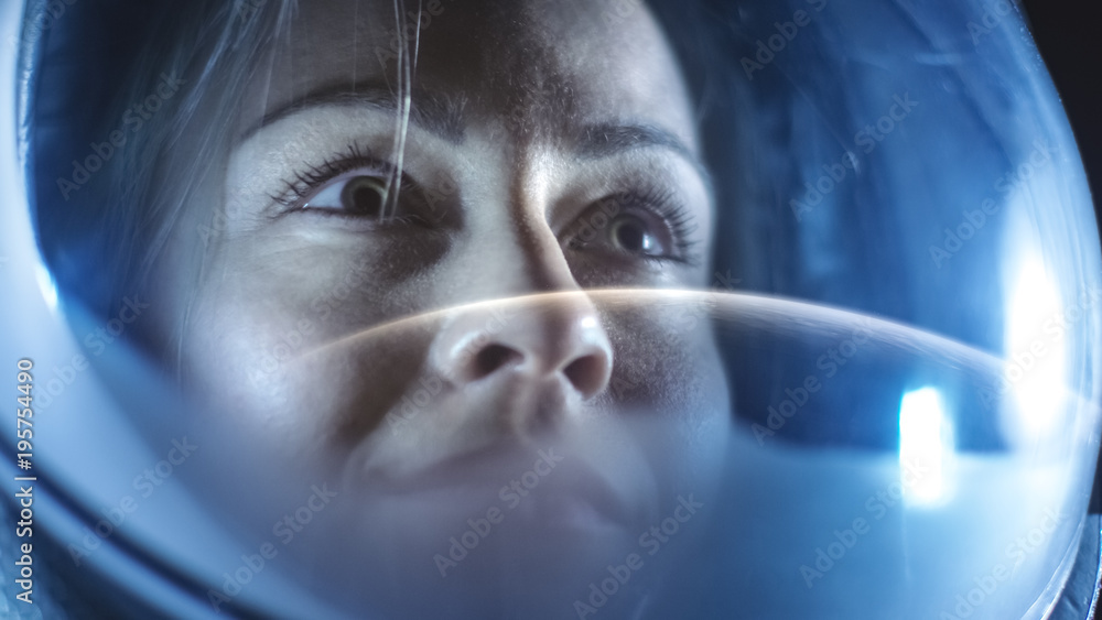 Portrait Shot of the Courageous Female Astronaut  Wearing Helmet in Space, Looking around in Wonder.