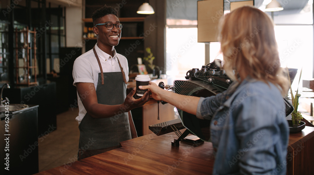 Barista serving customers inside a coffee shop