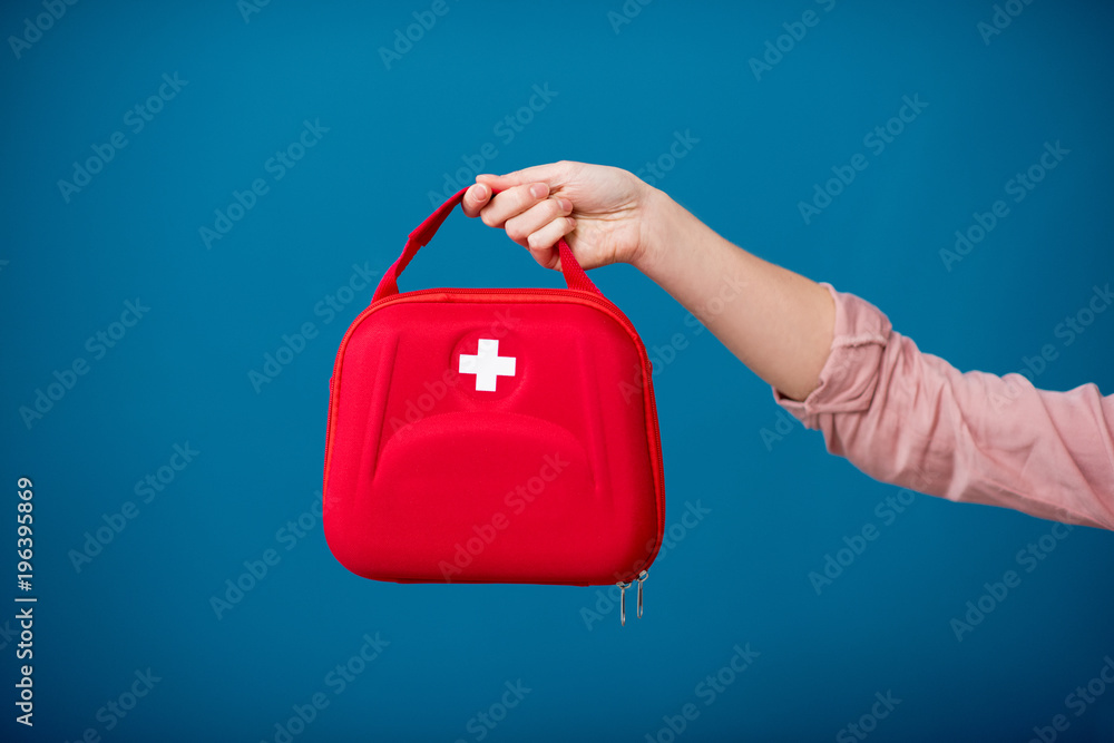 Holding first aid kit on the blue background