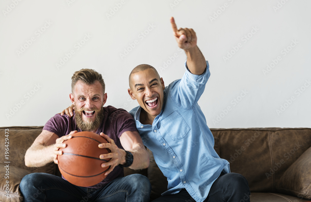 Man sitting together on a couch watching sport