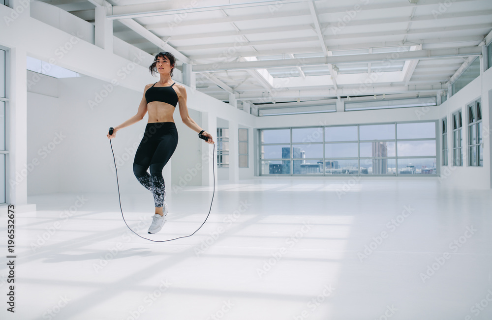 Woman skipping rope in fitness studio