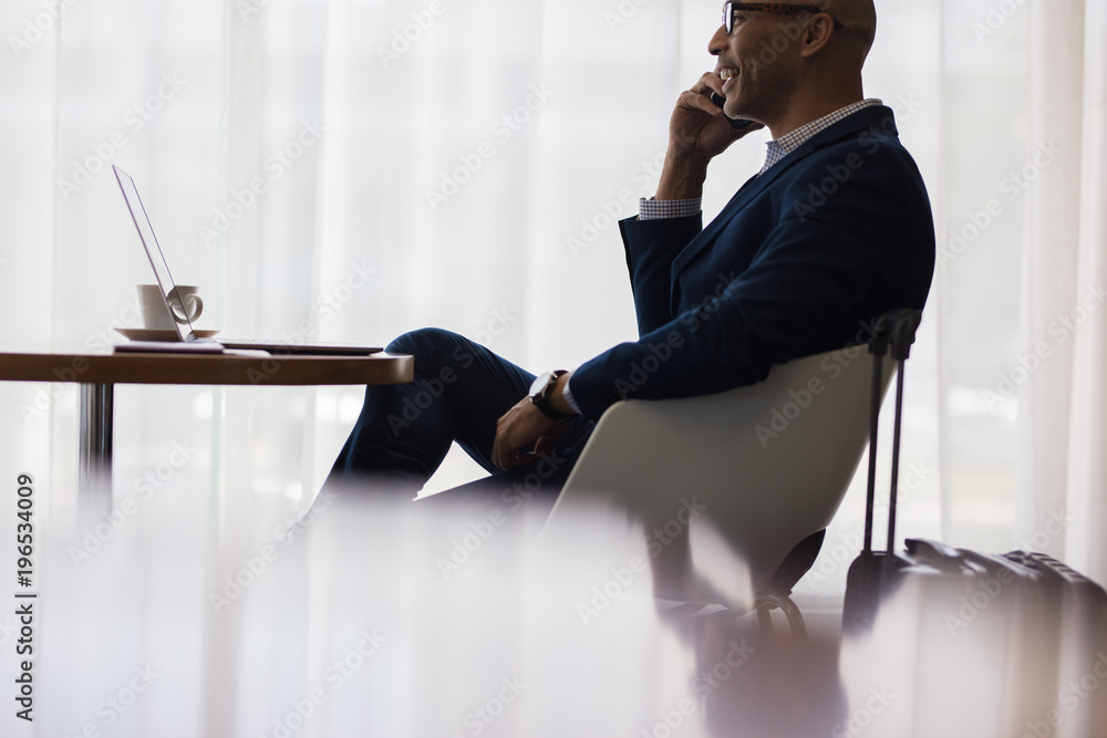 Business traveler making a phone call from airport lounge