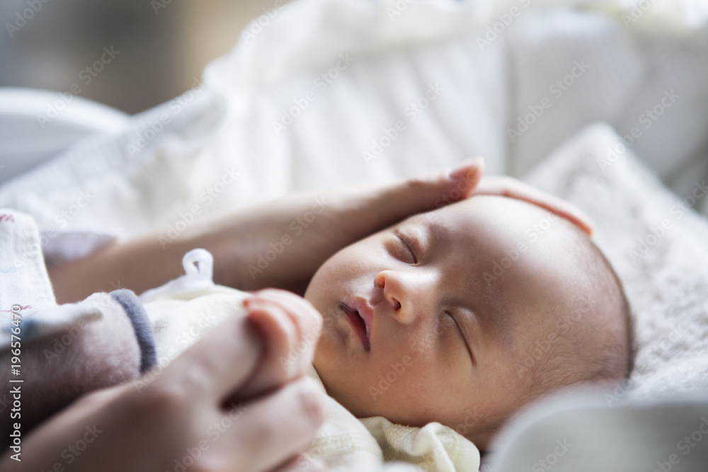 寝ている子供に優しく触れる母親