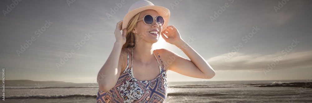 Composite image of beautiful girl with straw hat and sunglasses 