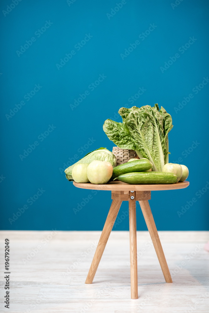 Table with healthy green food on the blue background indoors