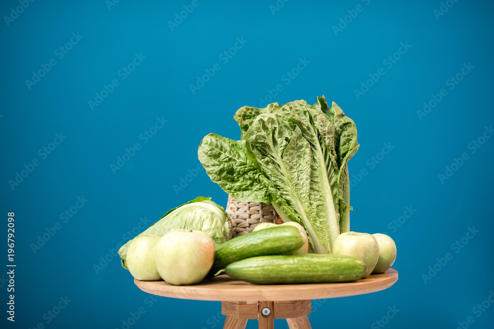 Table with healthy green food on the blue background indoors