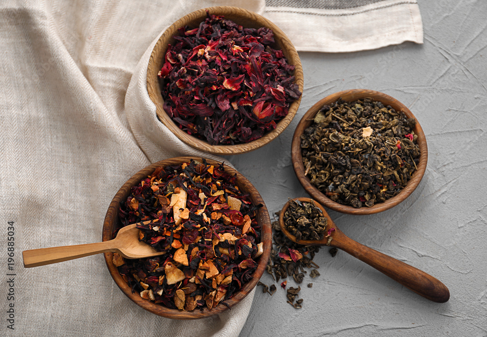 Different types of dry tea leaves on table