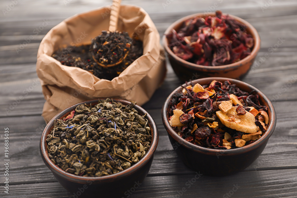 Different types of dry tea leaves on table