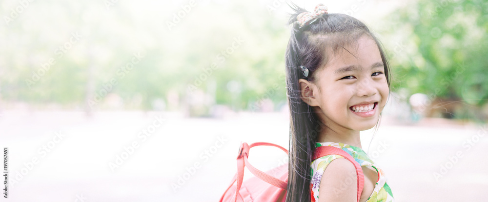 快乐的亚洲女孩背着背包从家上学