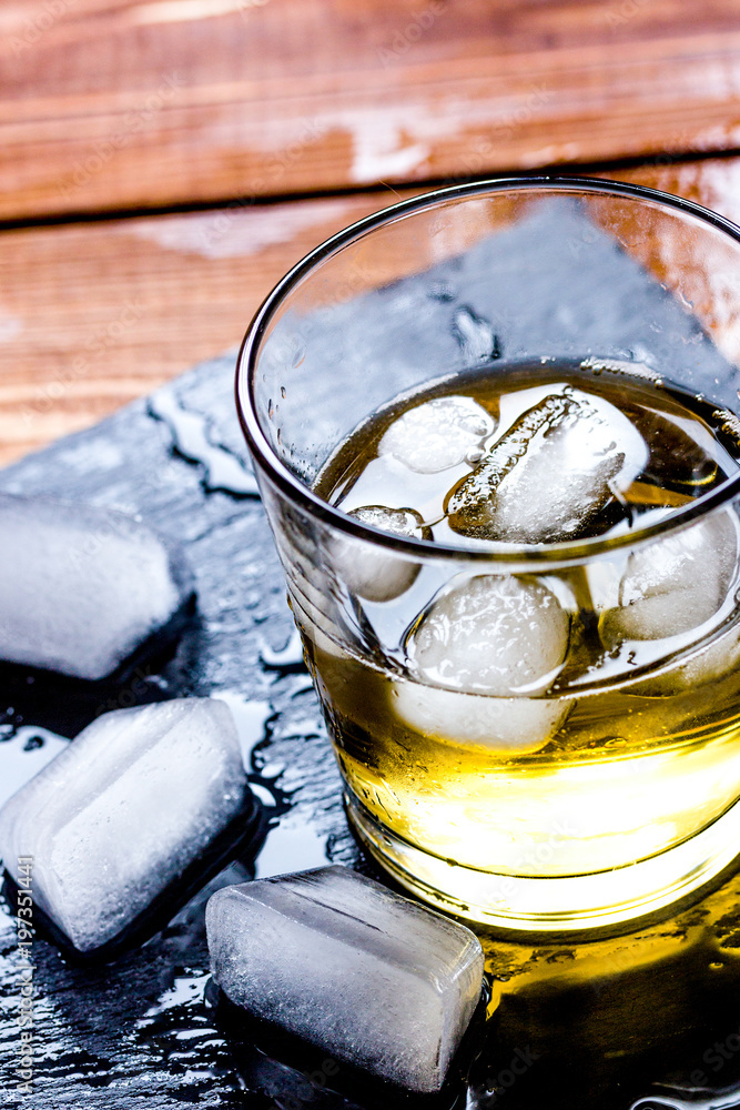 glass of whiskey on wooden background