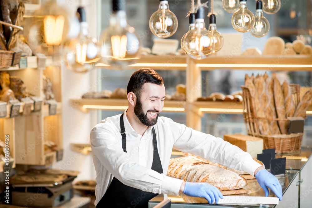 Bread seller working in the small and beautiful store with bakery products