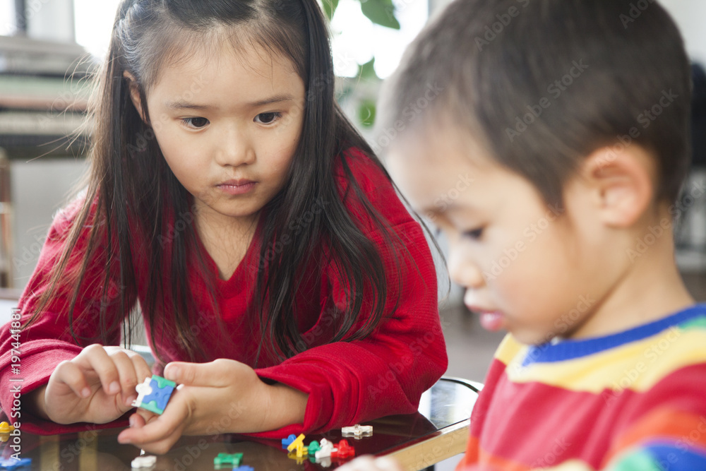 おもちゃで遊んでいる女の子と男の子。真剣な眼差し。