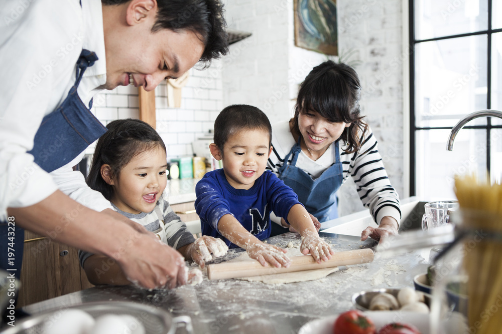 ピザの生地を麺棒でのばしている男の子。楽しそう。