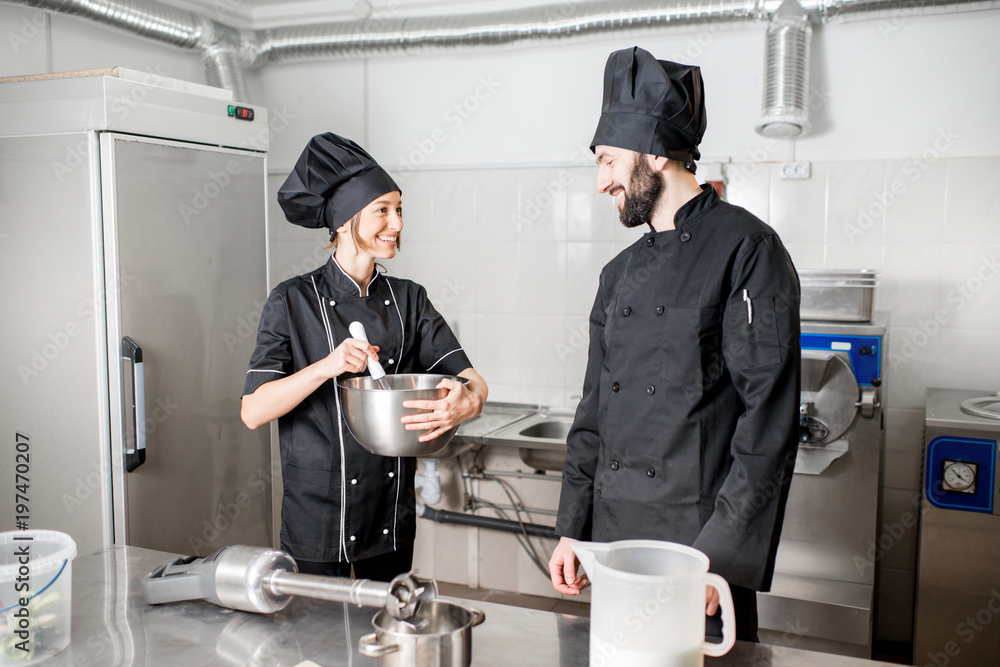 厨师与年轻女性助理一起制作冰淇淋，在专业餐厅混合食材