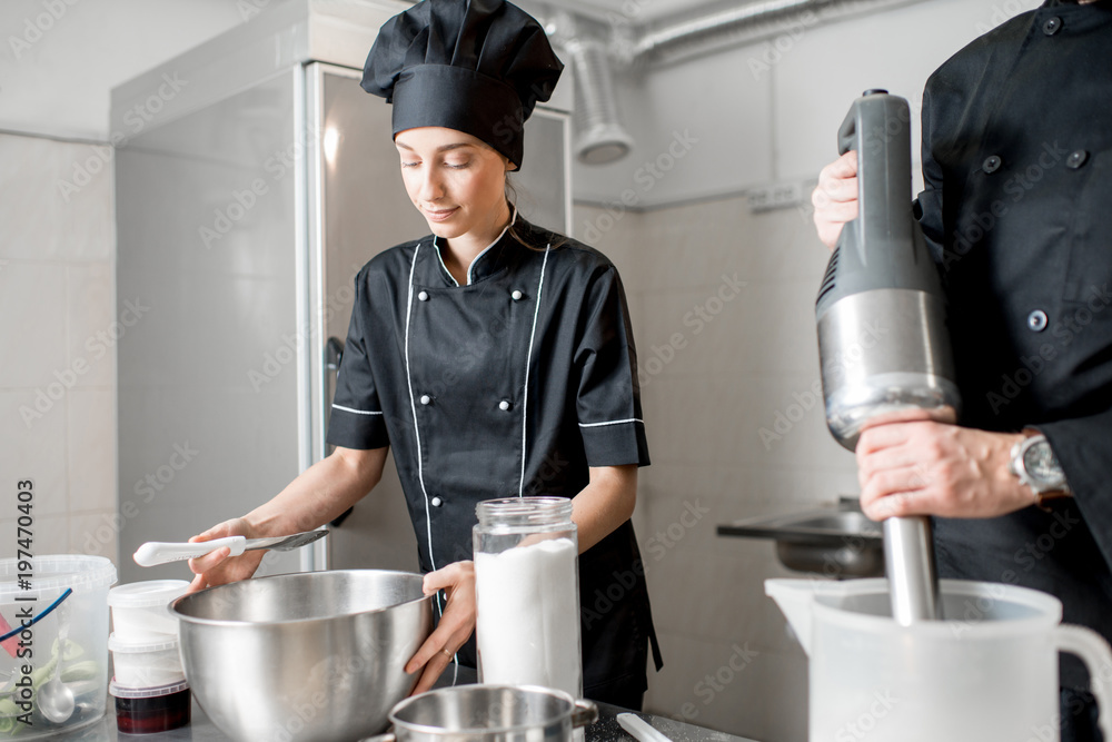 厨师与年轻女性助理一起制作冰淇淋，在专业餐厅混合食材