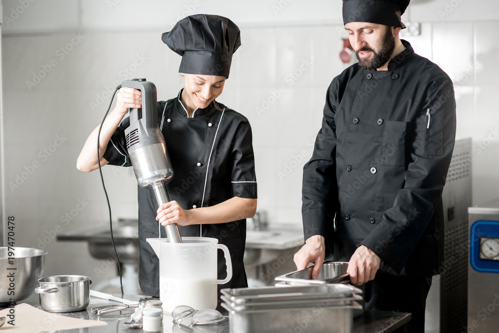 厨师与年轻女性助理一起制作冰淇淋，在专业餐厅混合食材