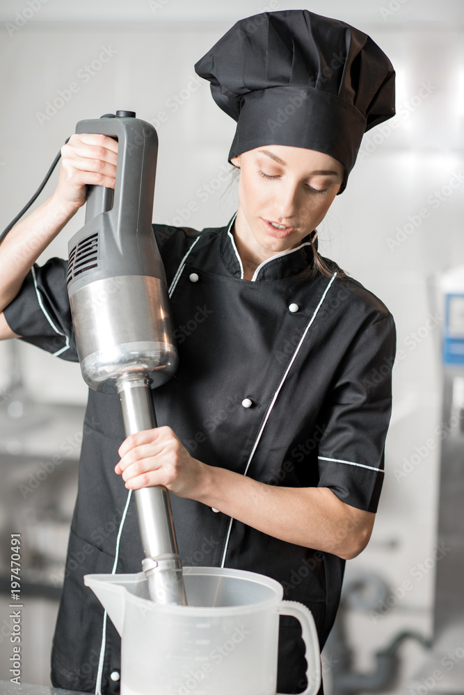 年轻女厨师在厨房用专业搅拌机搅拌牛奶制作冰淇淋