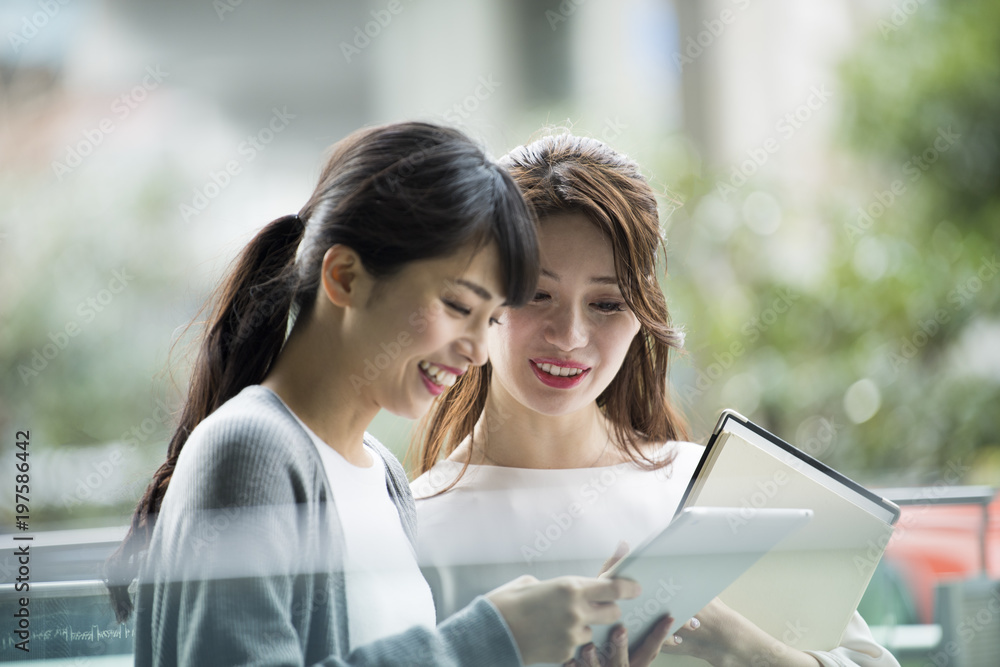 タブレットを眺める女性たちの横顔