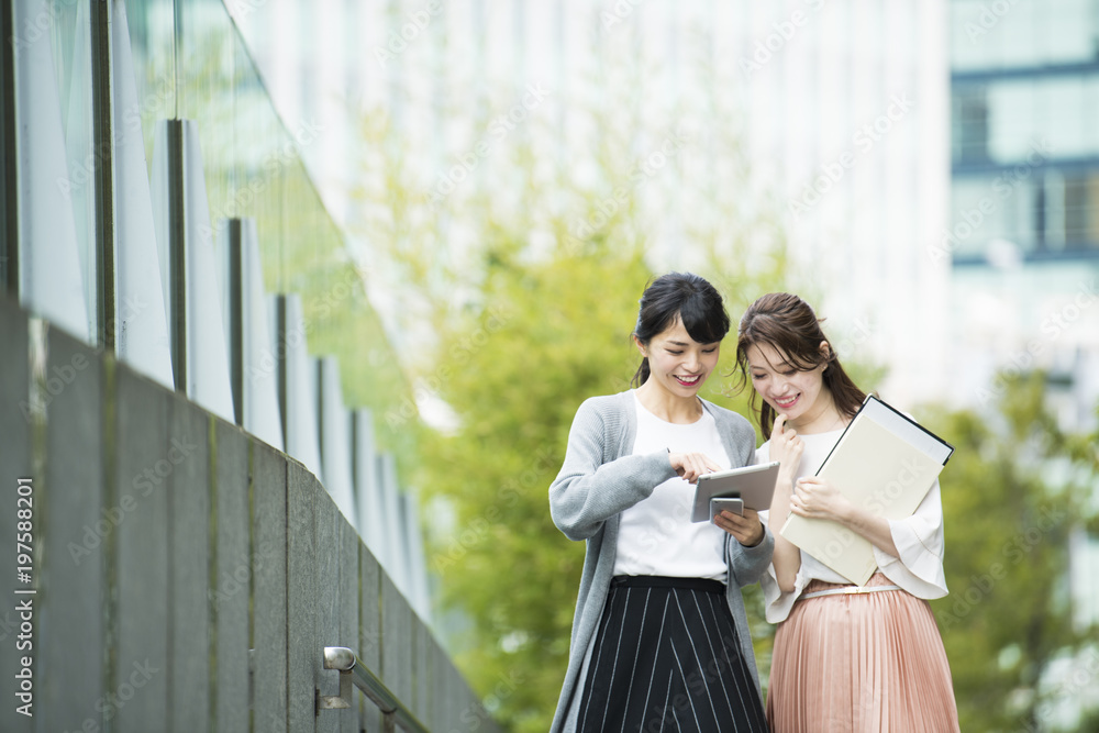 仲良くタブレットを眺めるOL