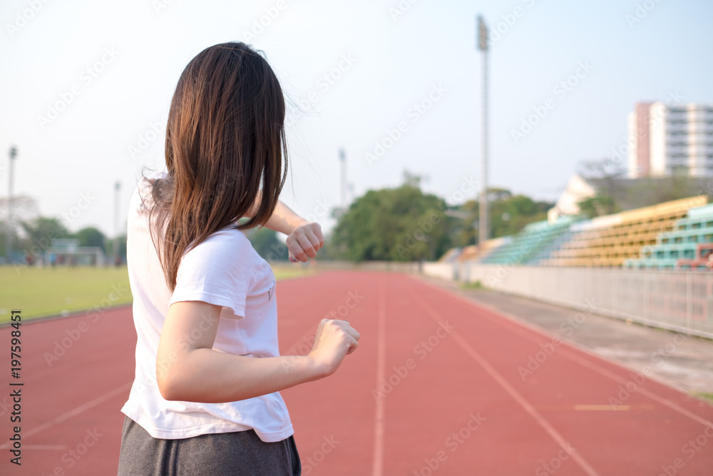 Young woman stretching her body before running on track. Healthy and exercise concept