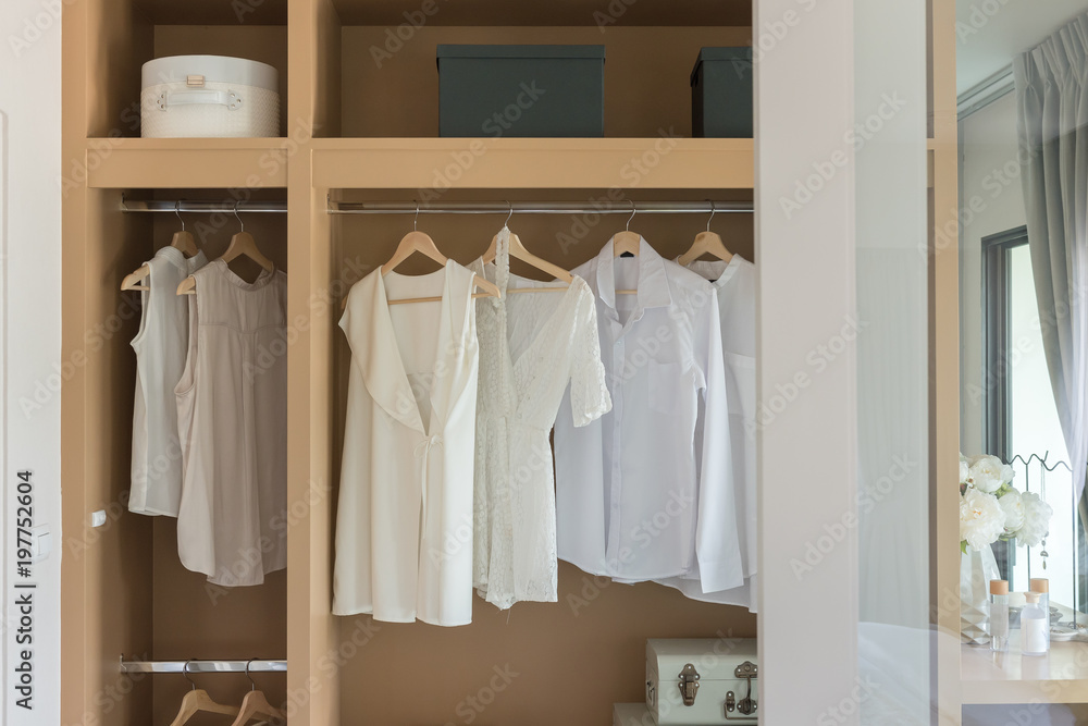 white color shirts hanging on rail