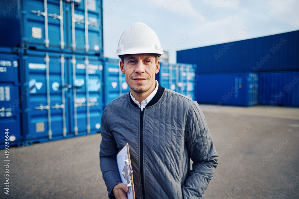 Smiling dock foreman standing in a commercial shipping yard