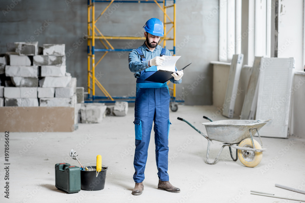 穿着工作服的建筑工人或工头熟练掌握结构和施工文件夹