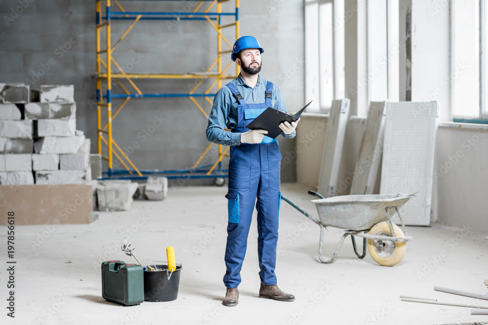 穿着工作服的建筑工人或工头熟练地将文件夹放在施工现场