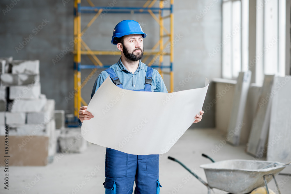 穿着工作服的建筑工人或工头熟练掌握施工现场的结构和蓝图