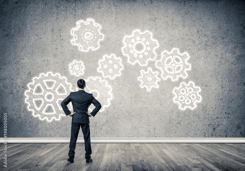 Cogwheel engine drawn on concrete wall as symbol for teamwork an