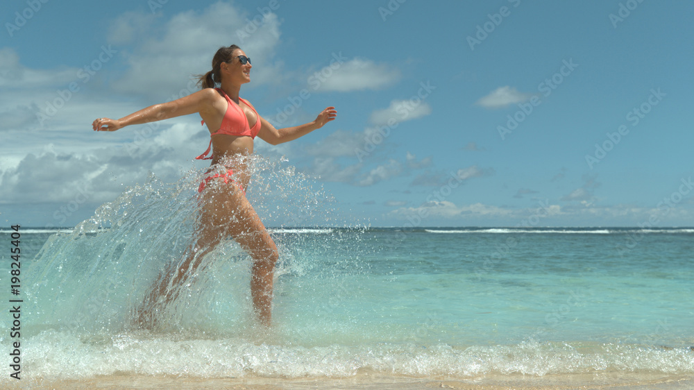 复制空间：令人惊叹的夏日阳光照在嬉戏的女孩身上，她在海里戏水。