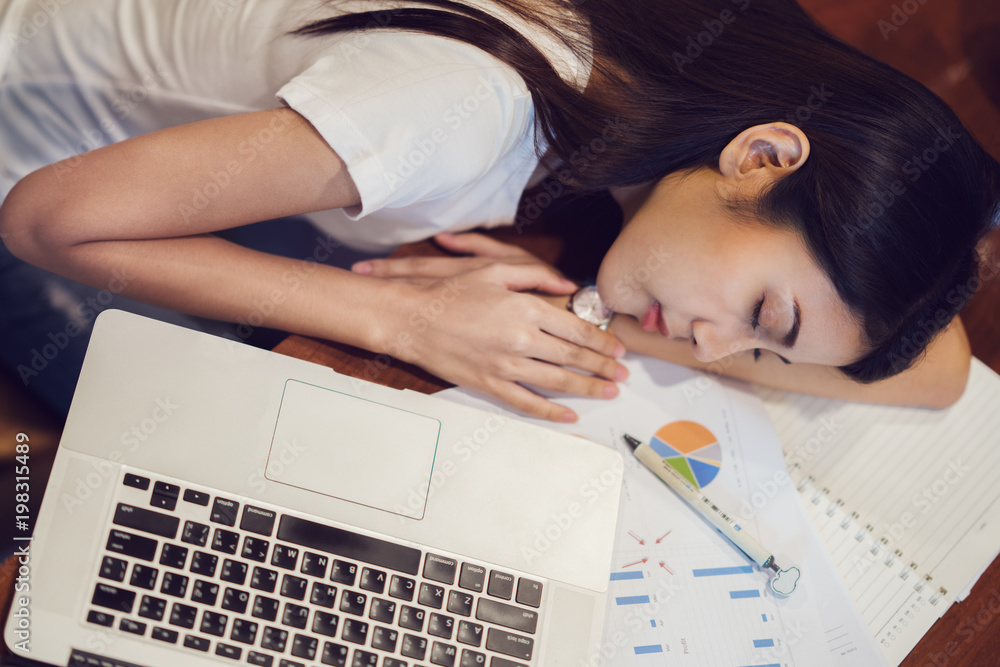 Student in university sleeping after finish home worke on the desk with computer notebook