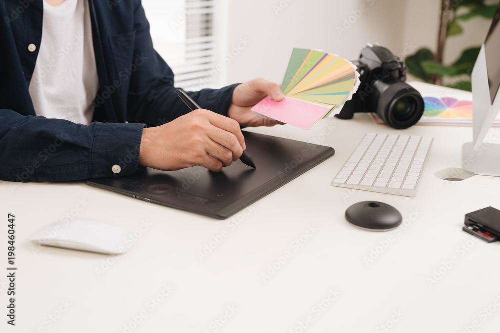 Male photographer at the studio doing some photo retouching