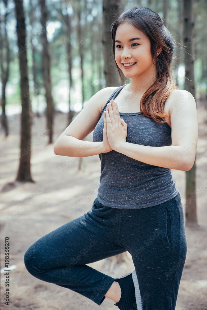 亚洲女孩周末在一片郁郁葱葱的松林里锻炼。运动女孩和李娜