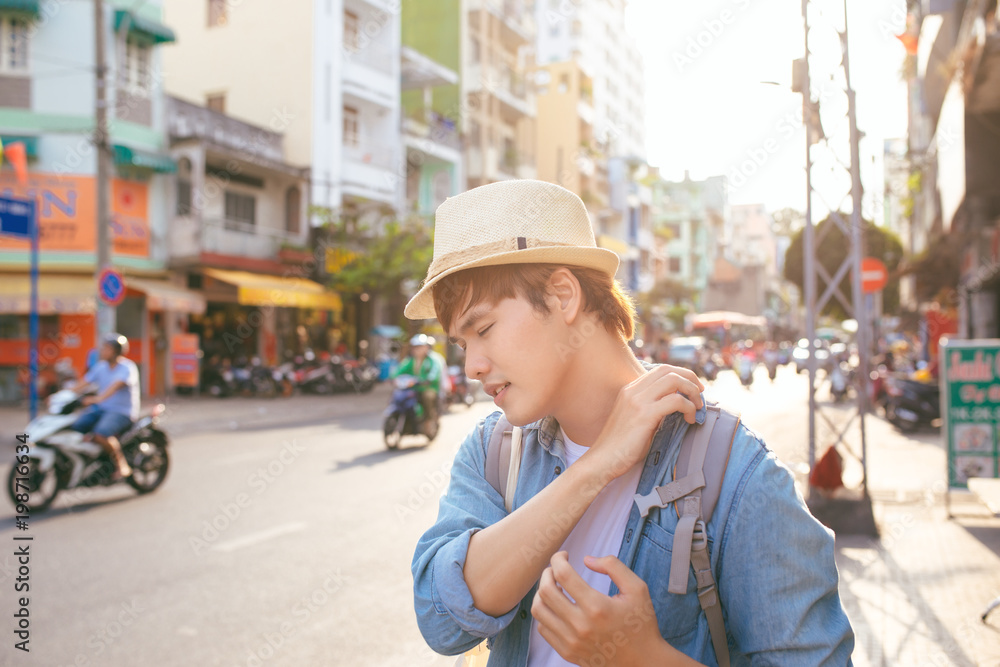 男性旅行者背着沉重的行李，长途旅行后表情疲惫