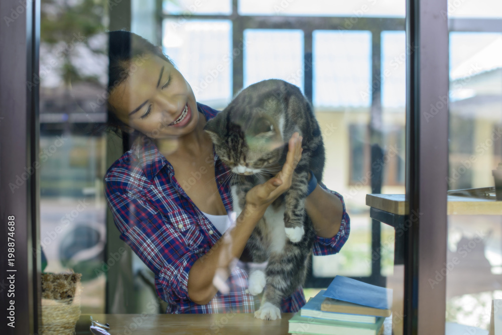 微笑的女人在和她可爱的猫玩耍