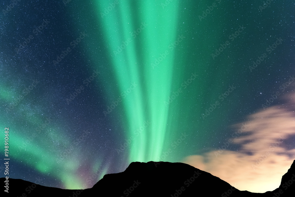 Aurora borealis and silhouette of mountains. Lofoten islands, Norway. Aurora. Green northern lights.