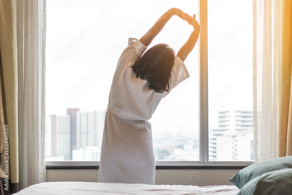 轻松的生活方式亚洲女性周末早上醒来，在舒适的城市休息