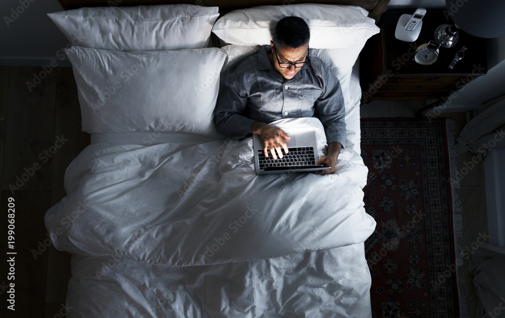 Man on bed using his laptop