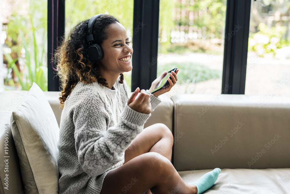 Woman enjoying music on her sofa