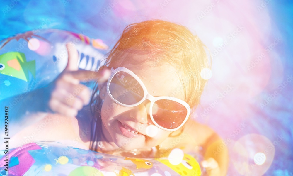 Beautiful little girl swimming at the pool