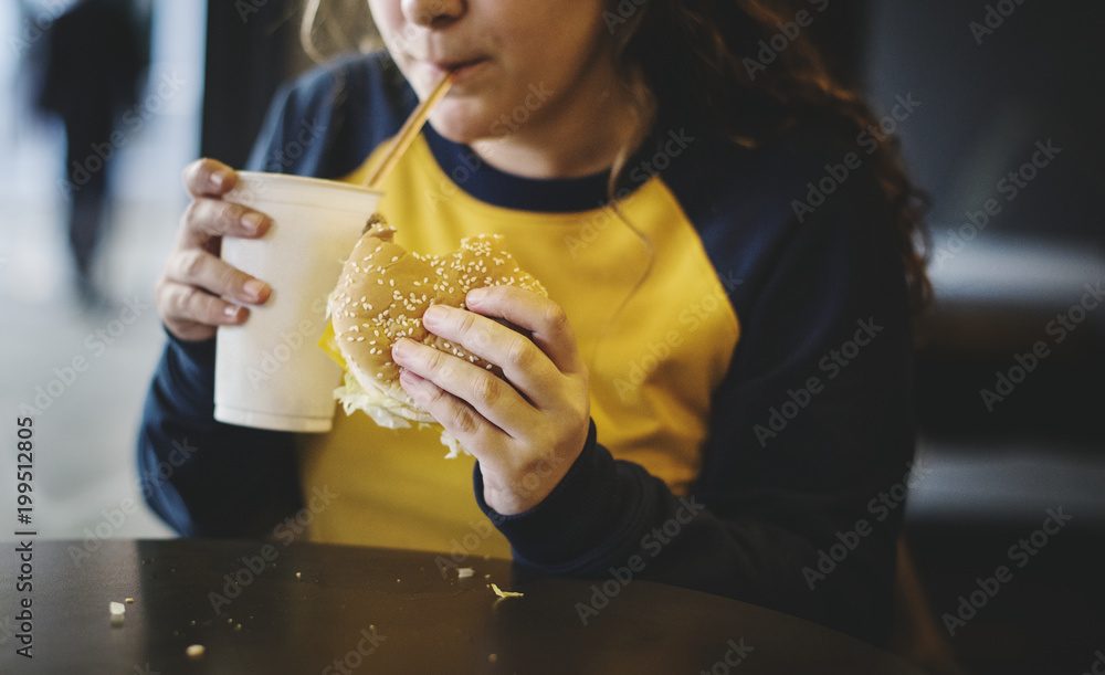 Close up of teenage girl eating hamburger obesity concept