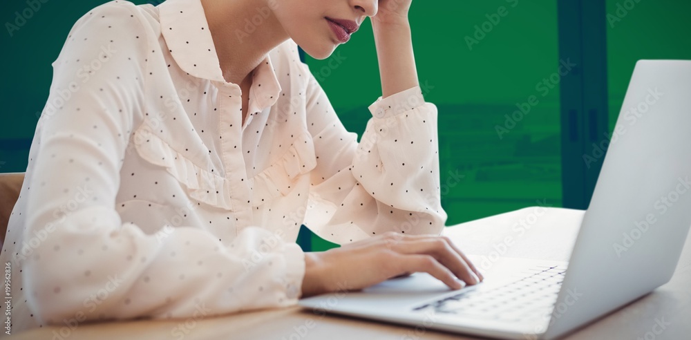 Composite image of tired businesswoman using laptop at desk