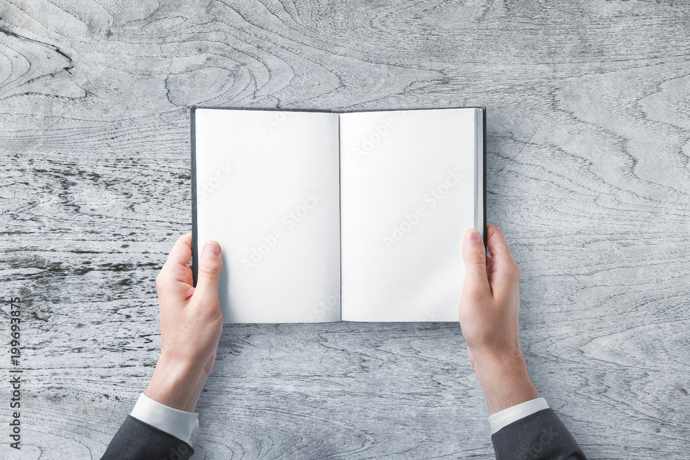 Businessman holding clean notepad