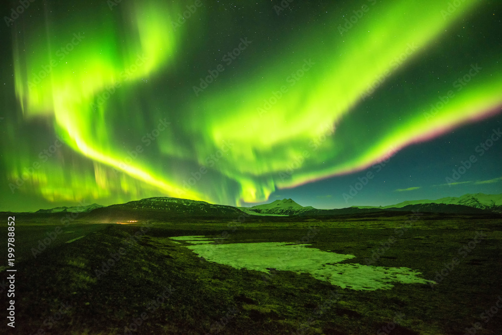 A wonderful night with Kp 5 . Northern lights mountain in Iceland. Background blurred.