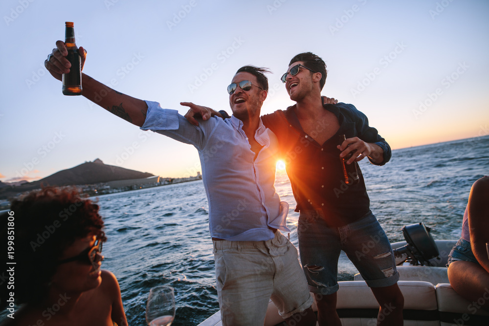 Men having a great time at evening boat party