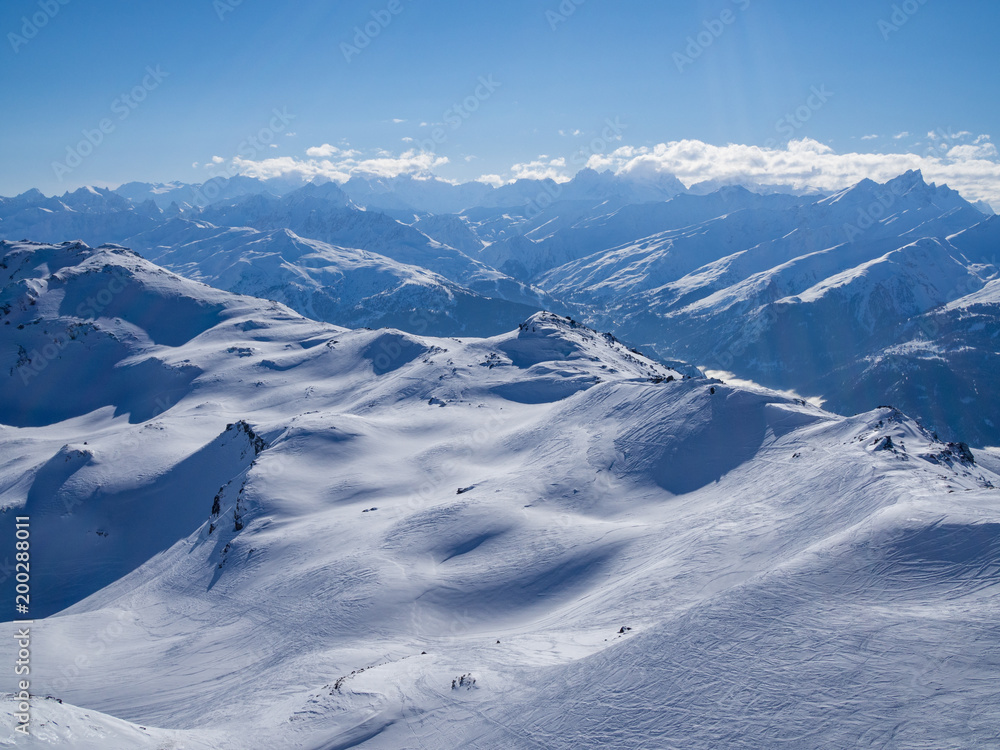 高山山脉白雪皑皑的山谷全景，有针叶松树和clou