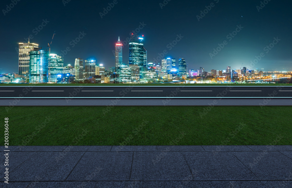 侧角视图，空旷的柏油路，草地、大理石地面和城市天际线背景。混合